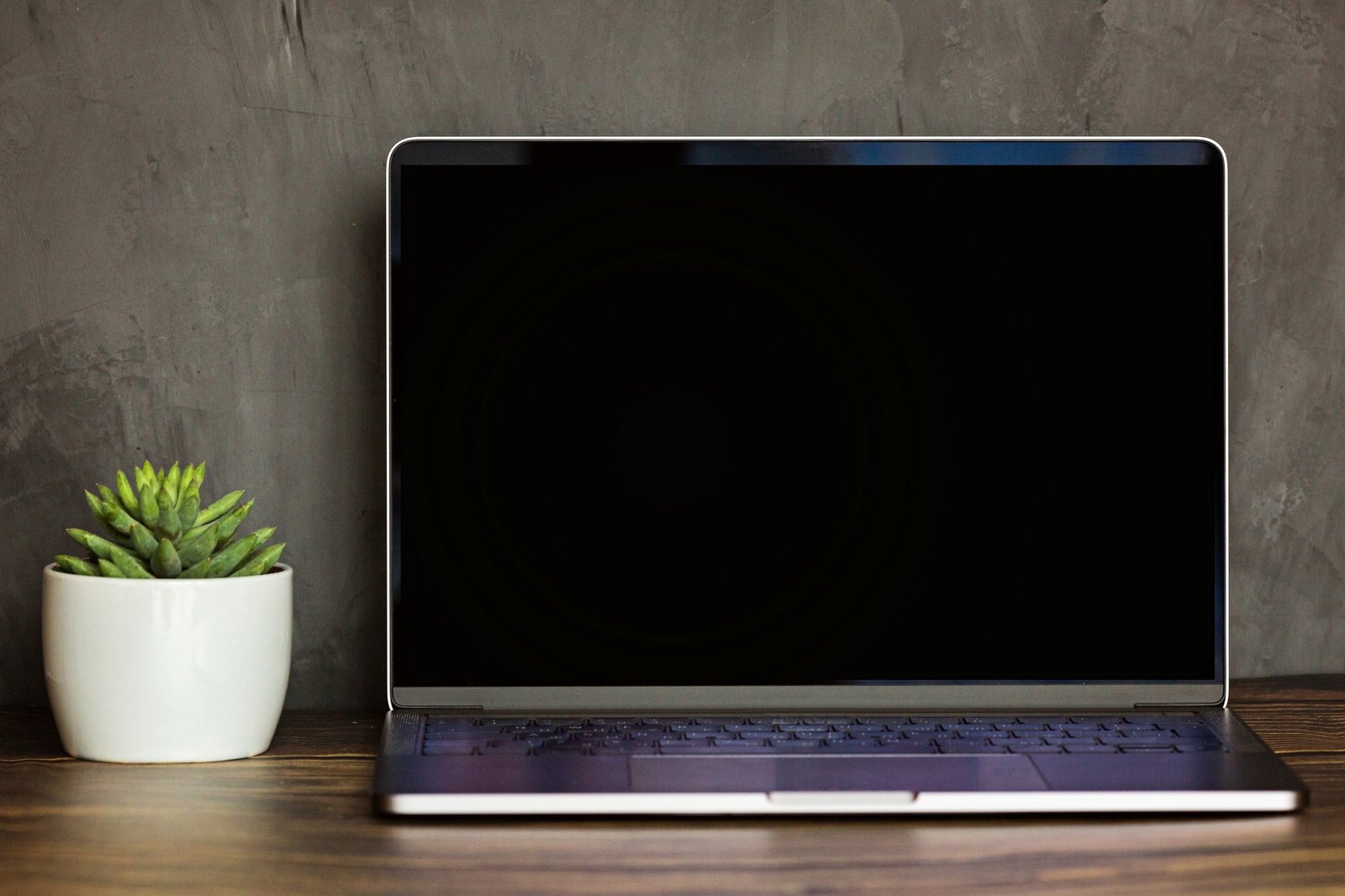 Laptop mit schwarzem Bildschirm auf dem Tisch